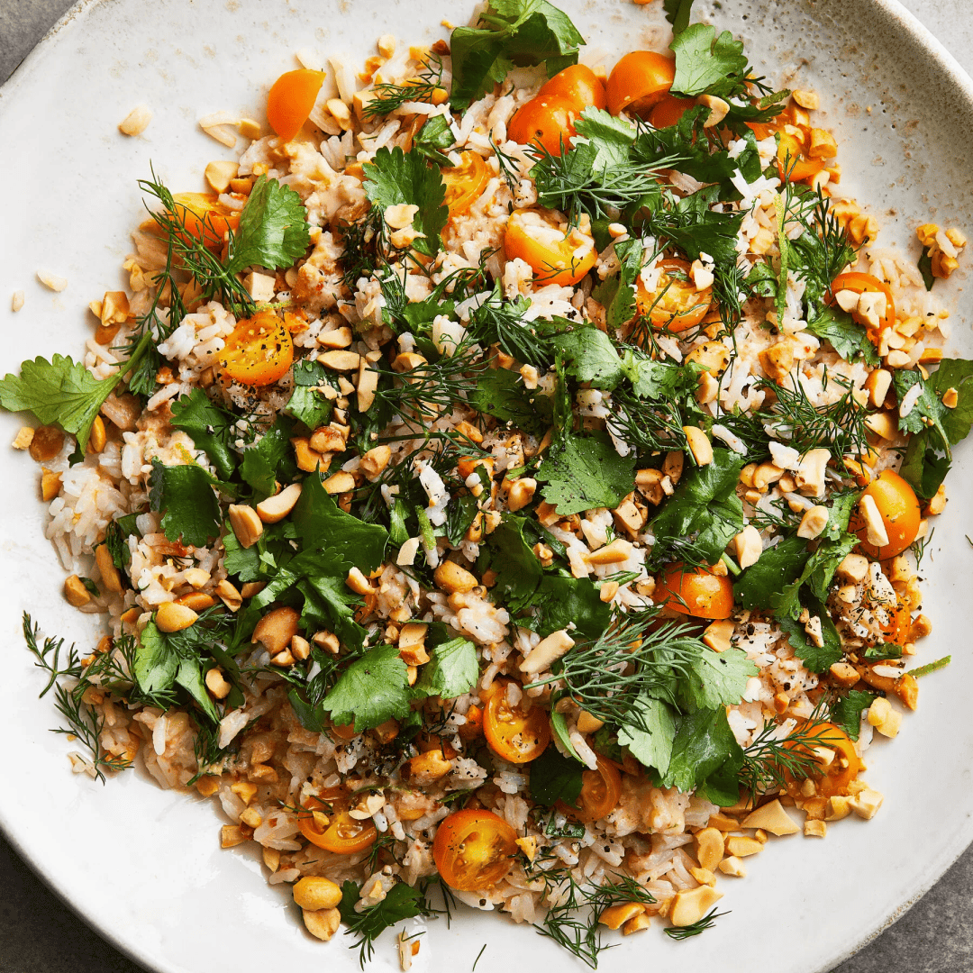 "A white bowl of coconut rice flecked with green peas, charred scallion and crushed peanuts, a lime wedge on the rim. A cheap ten-minute meal that feeds four."
