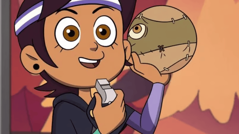 Cartoon girl with a white-and-purple headband smiles while holding a small gray object in one hand and a stitched tan ball with one eye in the other. Warm orange and red background suggests an outdoor scene at sunset. credit: lgbtqnation.